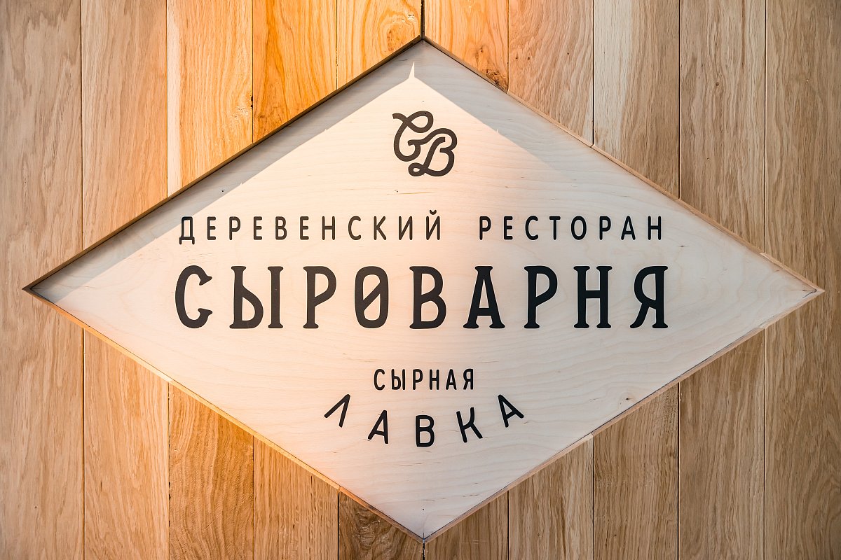 Фирменная вывеска «Сыроварня» на деревянной стене