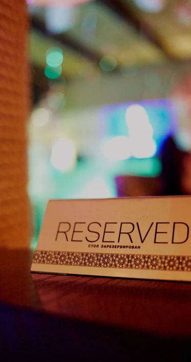 Табличка Reserved на столе ресторана «Сыроварня»
